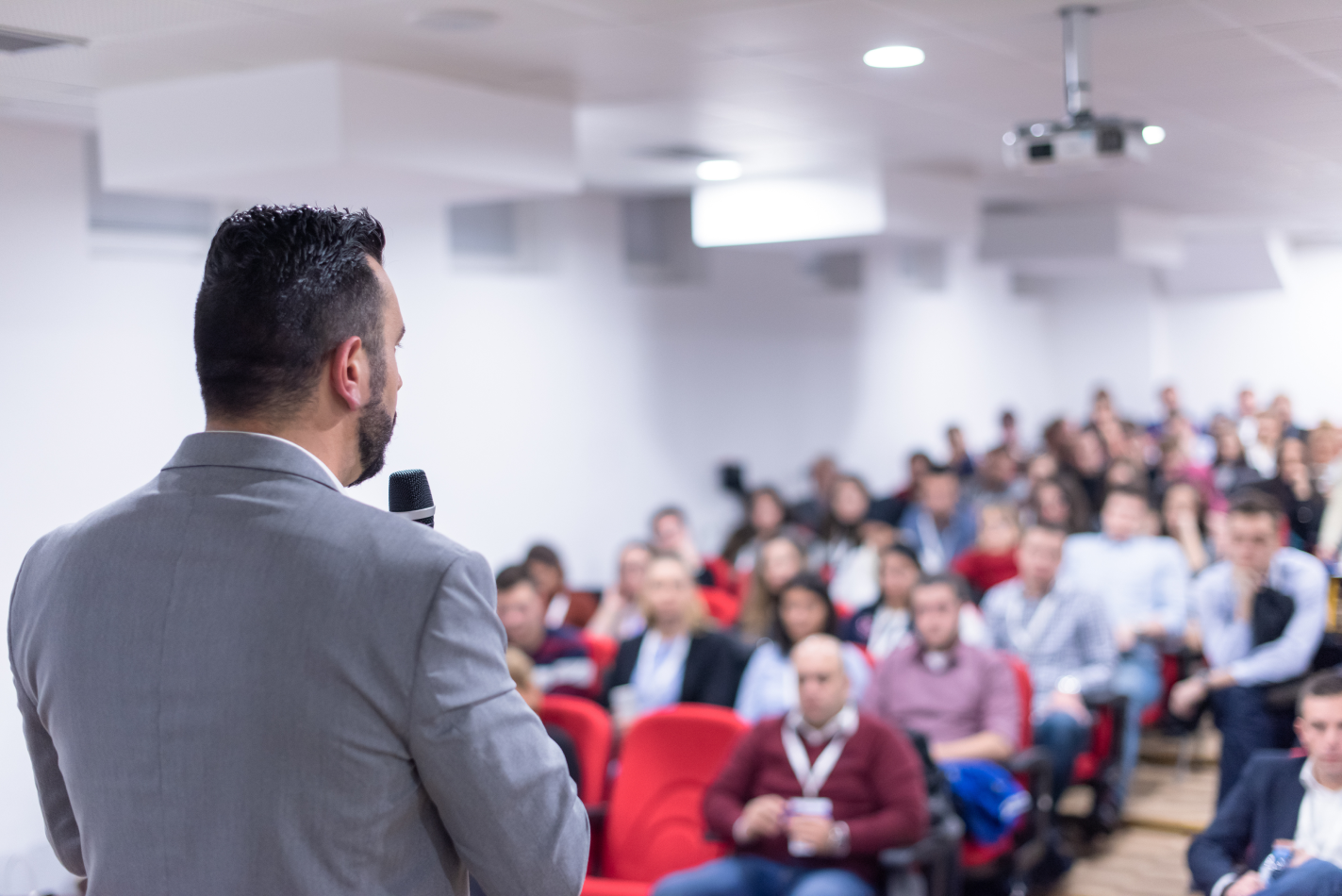 Business man giving speech in front of a crowd